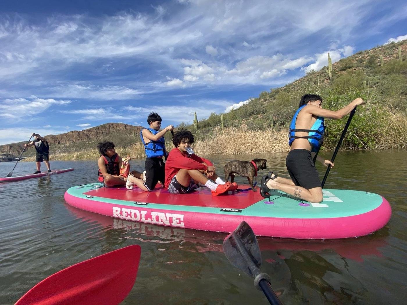Friends and a dog on the Redline party paddleboard