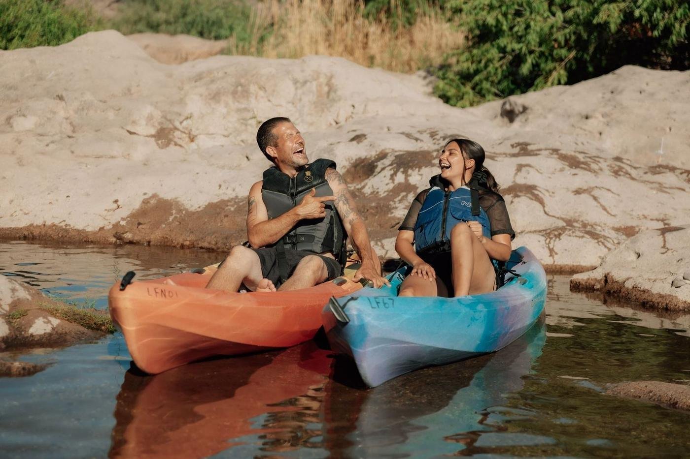 Two friends laughing in kayaks among the Salt River rocks