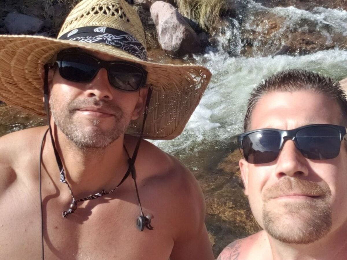 Two paddlers taking a selfie in front of a flowing creek at Canyon Lake